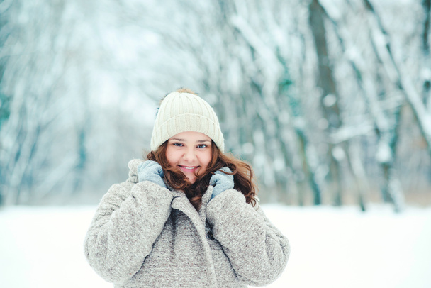 Teenage girl posing in snowy forest. Winter holidays concept. Girl outdoors in cold day. Winter fashion, sales and lifestyle concept. Winter woman portrait. Warm woman outfit. Winter mood - Photo, Image