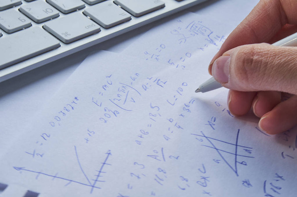 Blatt Papier gefüllt mit Berechnungen als Hintergrund. Matheaufgaben auf Graph mit Bleistift. Algebra in der Schule - Foto, Bild