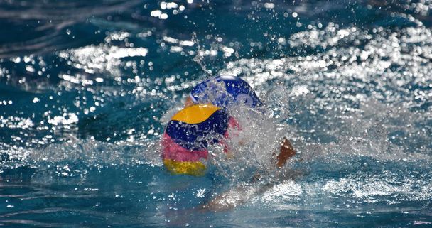 Waterpolo player swimming with the ball. - Photo, Image