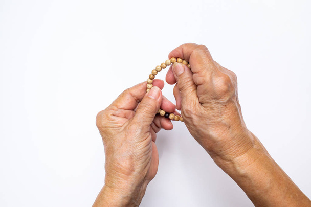 Aîné main de la femme compte bracelet en perles de bouddha isolé sur fond blanc
 - Photo, image