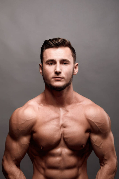 sexy starken Bodybuilder. Bodybuilder Mann mit perfektem Bauch, Schultern, Bizeps, Trizeps, Brust. - Foto, Bild