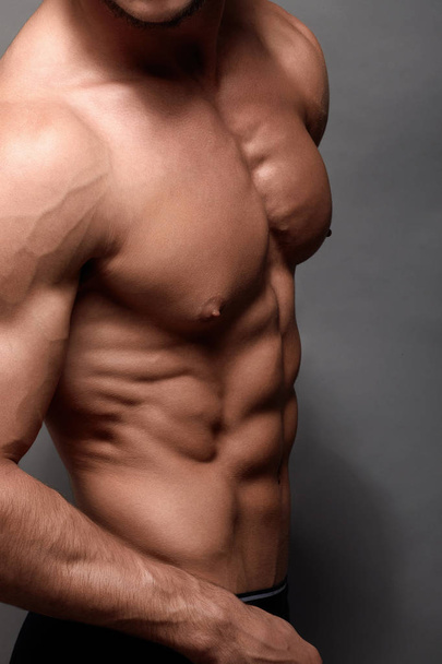 Sexy sterke bodybuilder. Bodybuilder man met perfecte abs, schouders, biceps, triceps, borst. - Foto, afbeelding