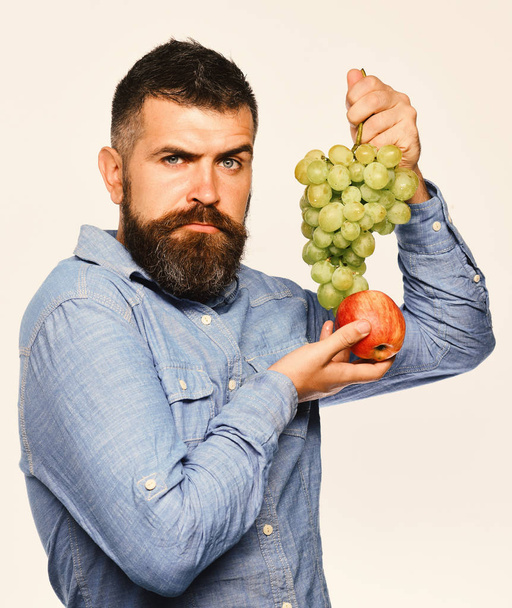 Viticulture and gardening concept. Farmer shows his harvest. Winegrower with serious face - Foto, Bild