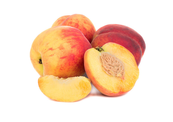 Useita tuoreita persikoita puoli ja viipale valkoisella taustalla
 - Valokuva, kuva
