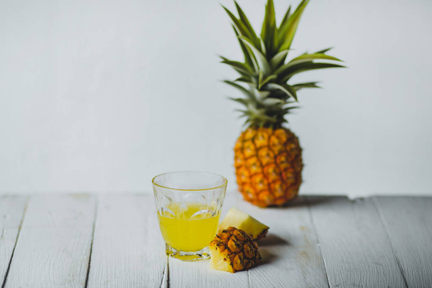 グラスにパイナップル ジュース ボトル白ウッドの背景 - 写真・画像
