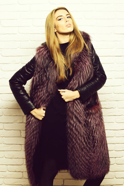burgundy fur with black leather sleeves and fashion makeup on white brick wall studio background, fashionable sexy woman in fur - Valokuva, kuva