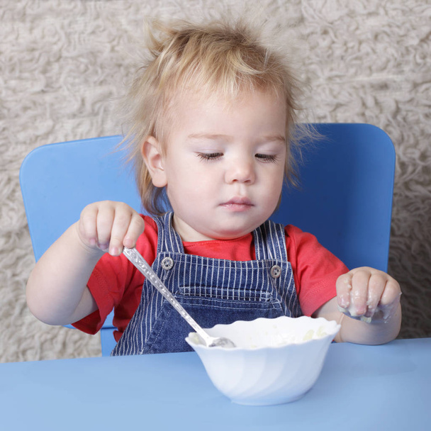 small child learns to eat with a spoon - Foto, immagini