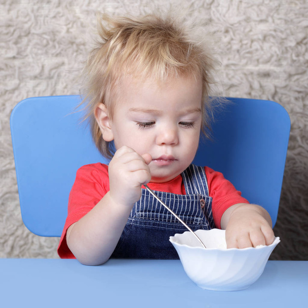 small child learns to eat with a spoon - Fotoğraf, Görsel