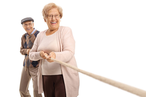 Elderly couple pulling a rope isolated on white background - Zdjęcie, obraz