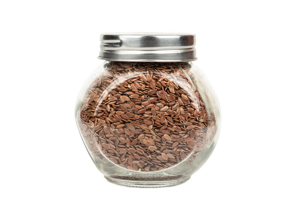 Glass jar filled with flax seeds on white background - Fotoğraf, Görsel