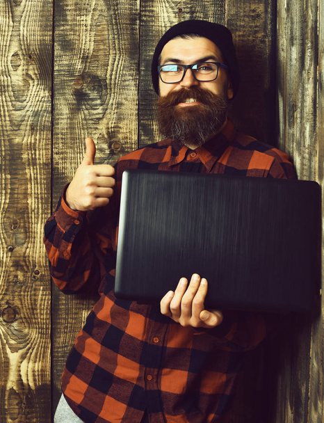 Bearded brutal caucasian hipster holding laptop - Zdjęcie, obraz