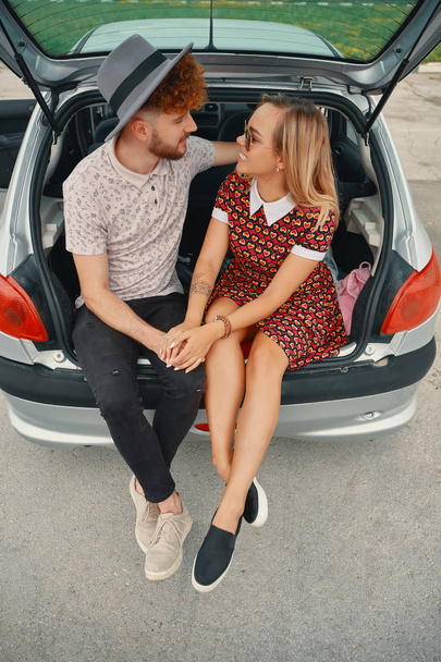 Happy couple have good time together while sitting in car trunk - Photo, Image