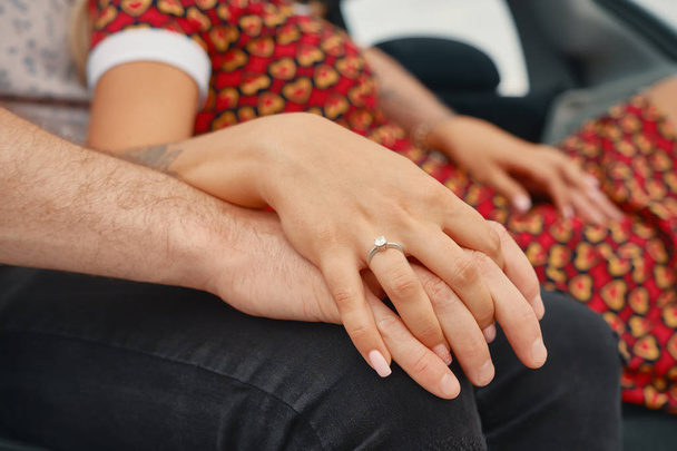 Крупним планом заручена пара тримає руки з алмазним кільцем
  - Фото, зображення