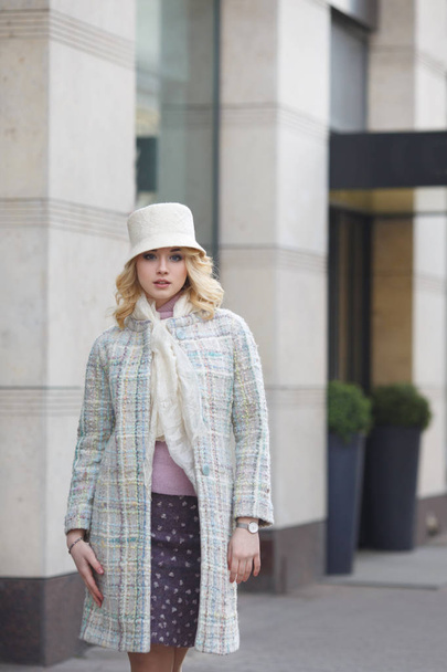 Beautiful stylish blond woman in coat and hat on city street. - Zdjęcie, obraz