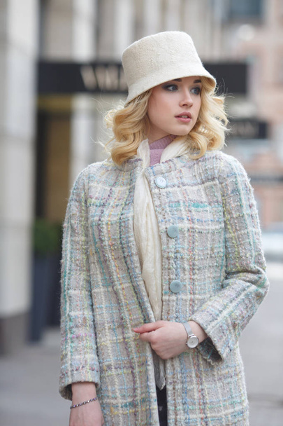 Beautiful stylish blond woman in coat and hat on city street. - Foto, Imagem