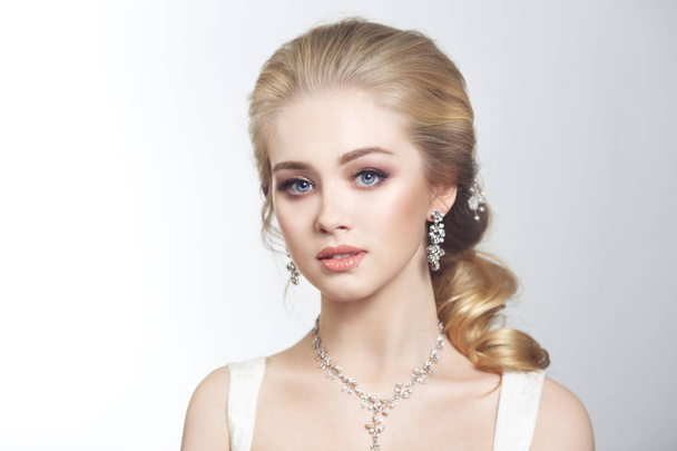 Beauty portrait of a cute blonde gorgeous bride with a beautiful hairstyle in jewelry. - Фото, изображение