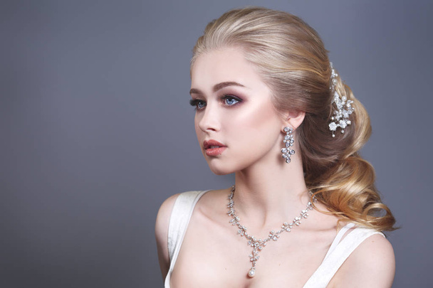 Beauty portrait of a cute blonde gorgeous bride with a beautiful hairstyle in jewelry. - Foto, Imagen