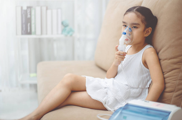 Şirin Asyalı çocuk hasta enhalasyon tedavisi inhaler yumuşak akışı bronchodilator duman maskesi tarafından. - Fotoğraf, Görsel