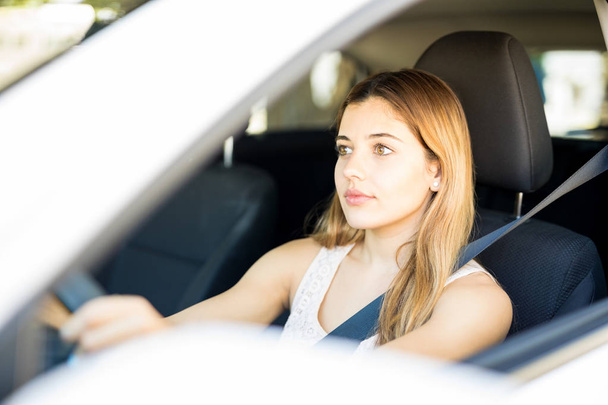 Mujer caucásica de buen aspecto conduciendo coche y prestando atención en la carretera
 - Foto, imagen