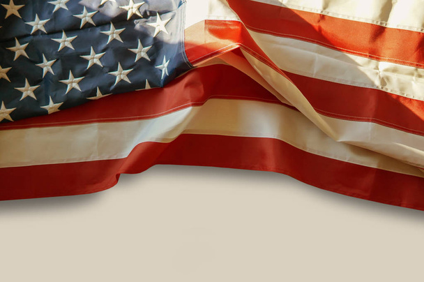 Αμερικανική σημαία κυματίζει πάνω από λευκό φόντο με αντίγραφο χώρο για το κείμενο. ήπια ζεστά χρώματα. Ημέρα ανεξαρτησίας, ημέρα μνήμης, ημέρα της εργασίας - Φωτογραφία, εικόνα