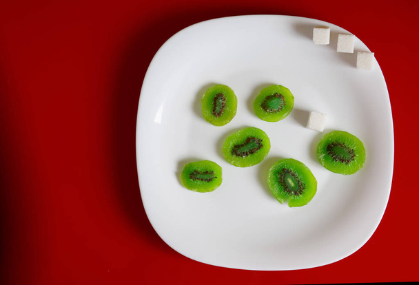 Candied fruit kiwi lies in a white plate. - Photo, Image