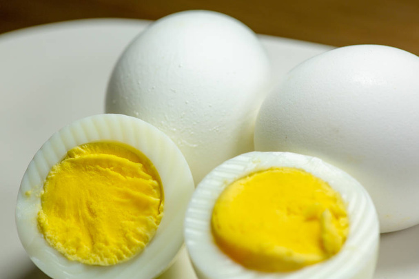 Ovos cozidos com um corte ao meio em uma placa na mesa da cozinha
 - Foto, Imagem