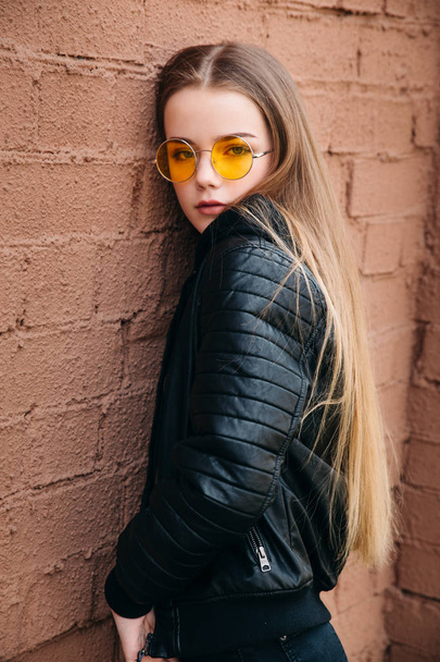 beautiful fashionable kid girl in yellow sunglasses in city - Foto, imagen