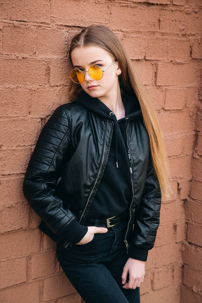 beautiful fashionable kid girl in yellow sunglasses in city - Photo, Image