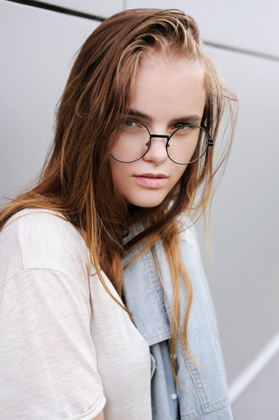 Street portrait of a red-haired girl wearing glasses. - Foto, Imagem