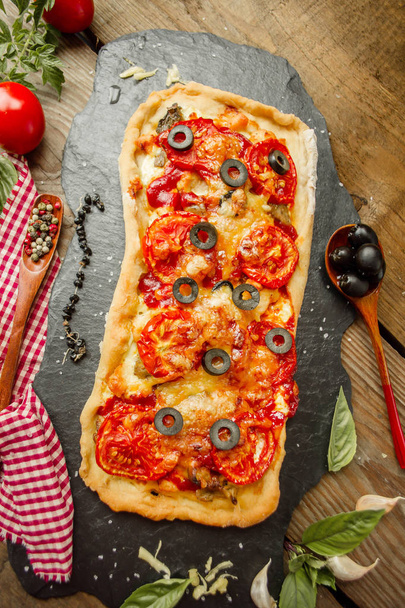 木の板にパルメザン チーズ サラミ長いピザ。ペパロニとチーズのピザにピーマン  - 写真・画像