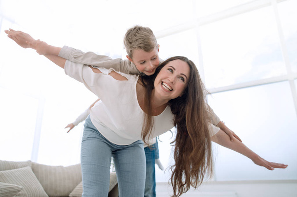 mother plays with her son in a spacious living room - Φωτογραφία, εικόνα