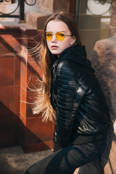 beautiful fashionable teenager girl with long hair in yellow sunglasses in city, Street fashion kid, - Фото, изображение