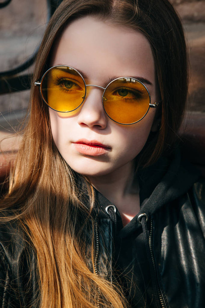 beautiful fashionable teenager girl with long hair in yellow sunglasses in city, Street fashion kid, - 写真・画像