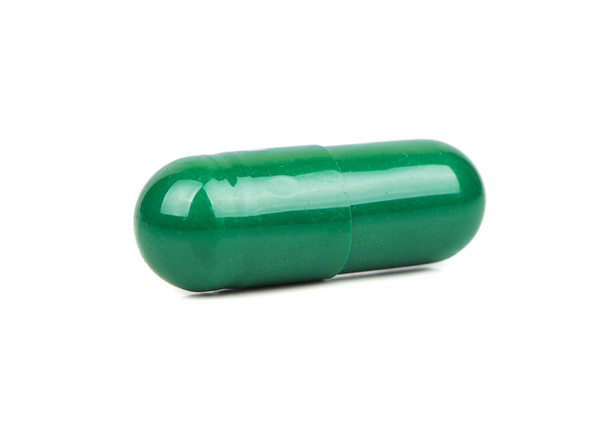 Groene kruiden capsule geïsoleerd op witte achtergrond - Foto, afbeelding