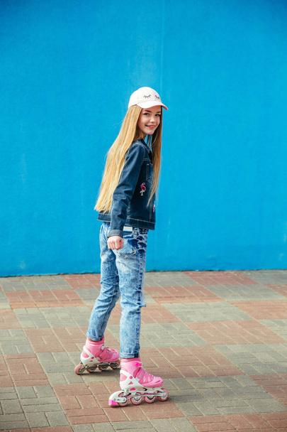 Young girl on rollerblades in the city - 写真・画像