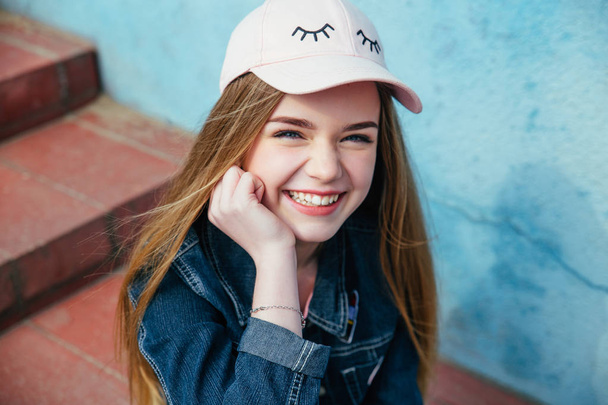 Portrait closeup beautiful young girl in city. Smiling girl in hat - Foto, imagen