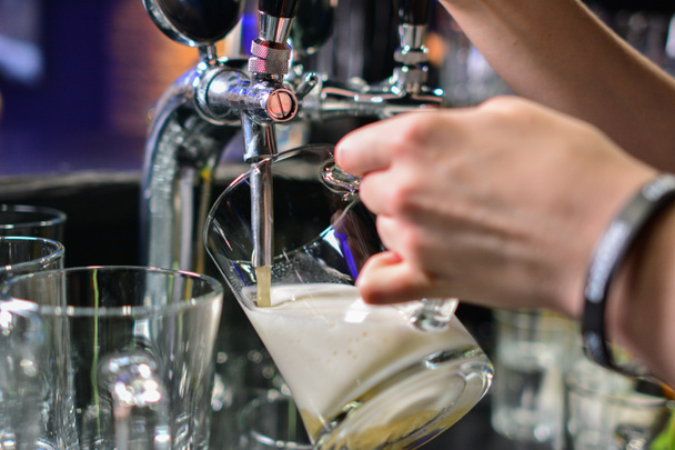 Lähikuva baarimikko käsi oluen hana kaatamalla syväys lager olutta
 - Valokuva, kuva