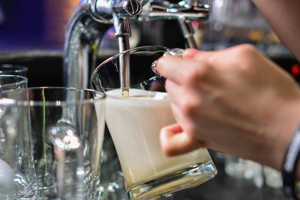 Primer plano de la mano del barman en el grifo de la cerveza vertiendo una cerveza de cerveza de barril de barril
 - Foto, Imagen