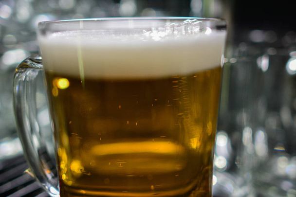 Barmen elini bira fıçısına koyup bira dökerken yakın plan. - Fotoğraf, Görsel