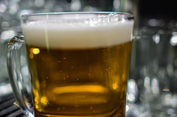 Barmen elini bira fıçısına koyup bira dökerken yakın plan. - Fotoğraf, Görsel