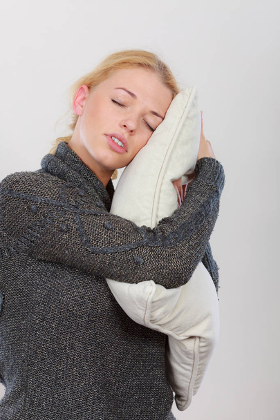 Sleep time, warm bedding, tiredness concept. Happy sleepy tired woman smiling and holding cozy white pillow - Valokuva, kuva