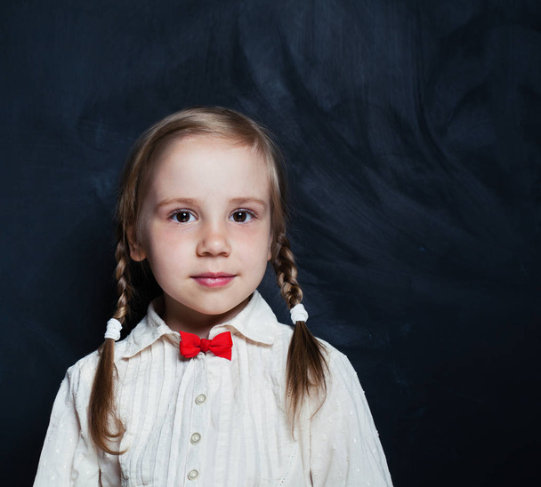 Cute little girl. Happy Child on empty blackboard background with copy space. Back to school. - Fotoğraf, Görsel