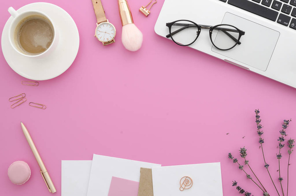 flach liegender weiblicher Arbeitsbereich mit Damenbüro-Schreibtisch-Laptop, Lavendel, Make-up-Accessoires, Notizbuch, Brille, Kaffee. von oben femininer rosa Hintergrund. - Foto, Bild
