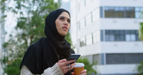 Thoughtful woman in hijab using mobile phone 4k - 映像、動画