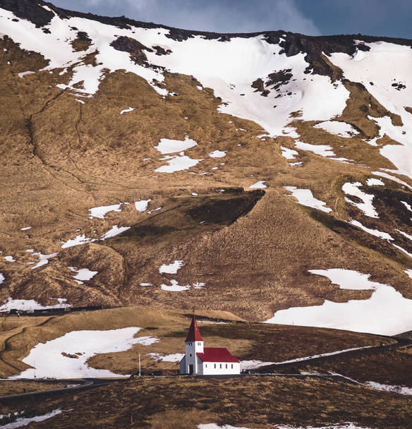 Vista panorámica del Vik al atardecer. Iglesia típica de madera de color rojo en Vik, Islandia en invierno
. - Foto, Imagen