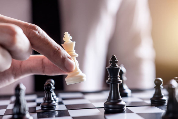 Hand of confident businessman use king chess piece white playing chess game to development analysis new strategy plan, business strategy for win and success. - Fotoğraf, Görsel