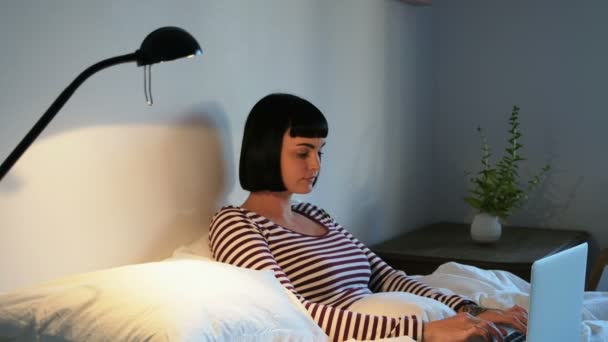 Woman using laptop in bedroom at home 4k - Felvétel, videó