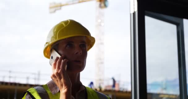 Female engineer talking on mobile phone in office 4k - Imágenes, Vídeo