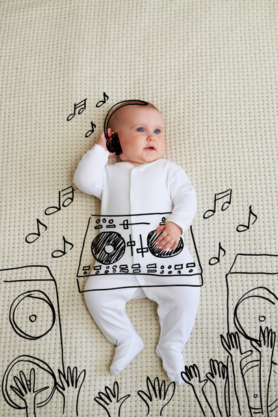Cute DJ baby girl wearing headphones playing music at mixer - Zdjęcie, obraz