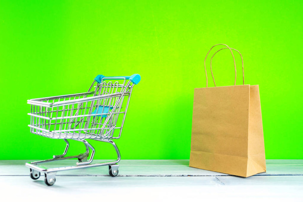 Einzelhandel Einkaufskonzept Miniatur-Einkaufswagen auf grünem Bildschirm - Foto, Bild